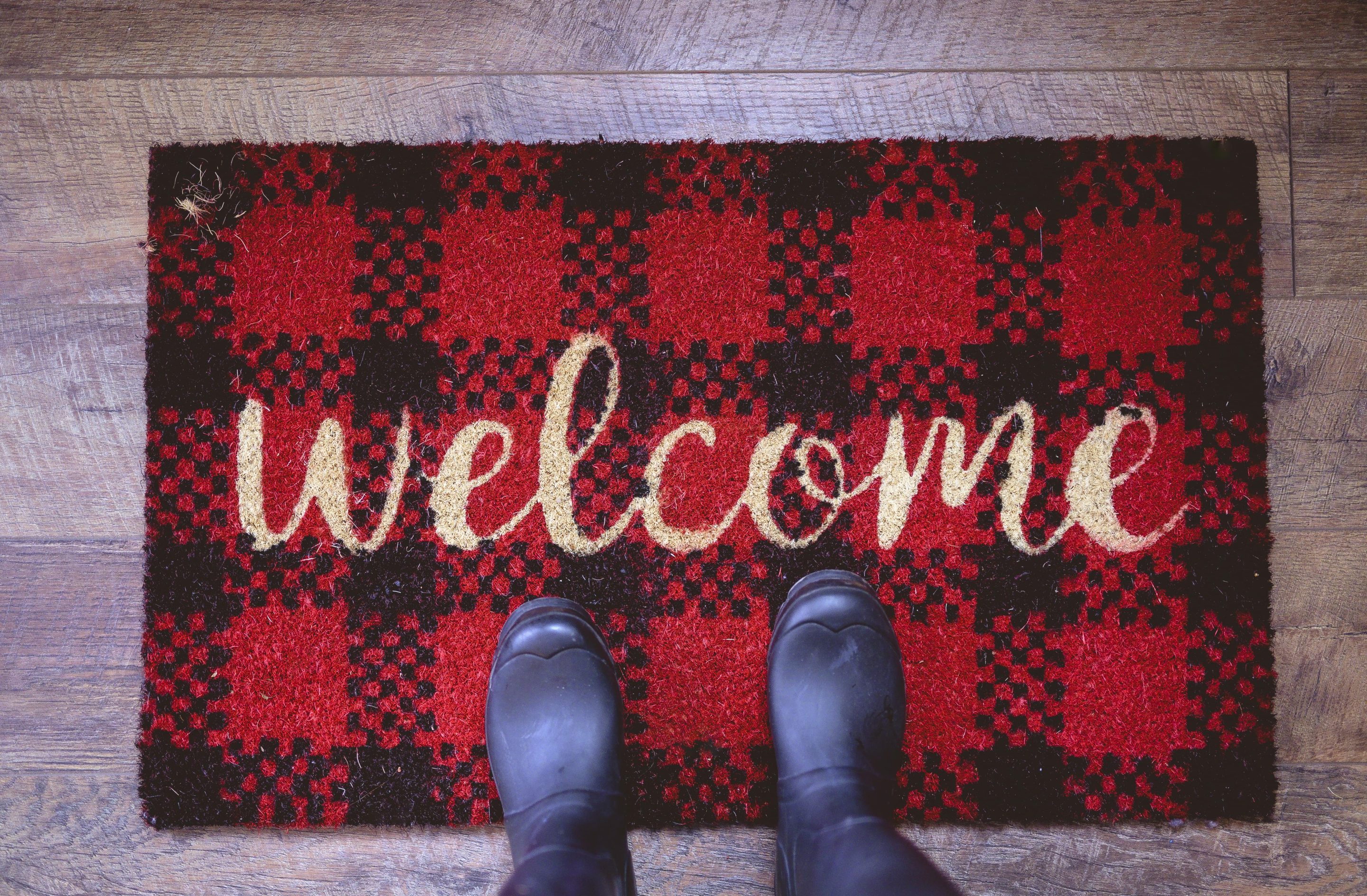 overhead-shot-person-standing-welcome-mat