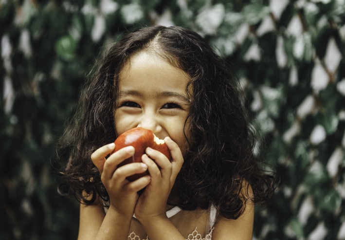 A young girl smiles for the camera thanks to the family visa services provided by VEVS Global