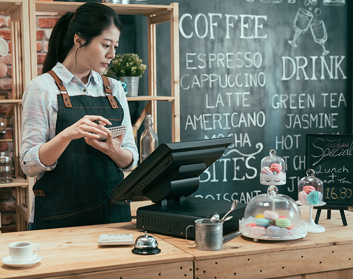 female waitress checking order on terminal. Temporary Skill Shortage Visa