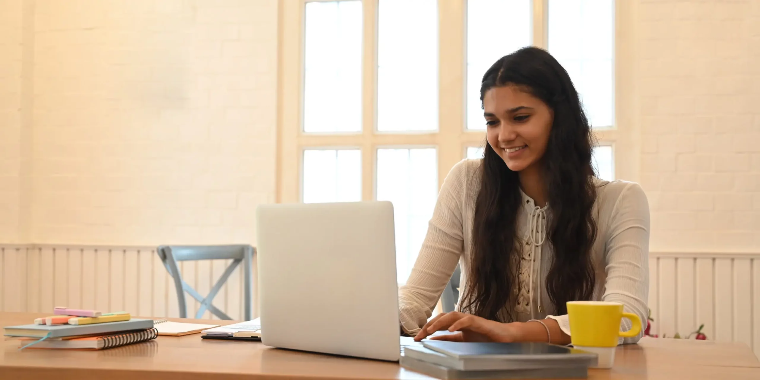 university-student-is-learning-lessons-online-while-sitting-wooden-working-desk-scaled